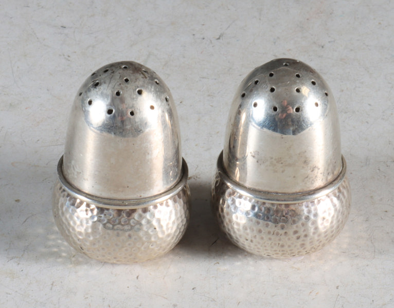 Et par saltdrysser i sølv.