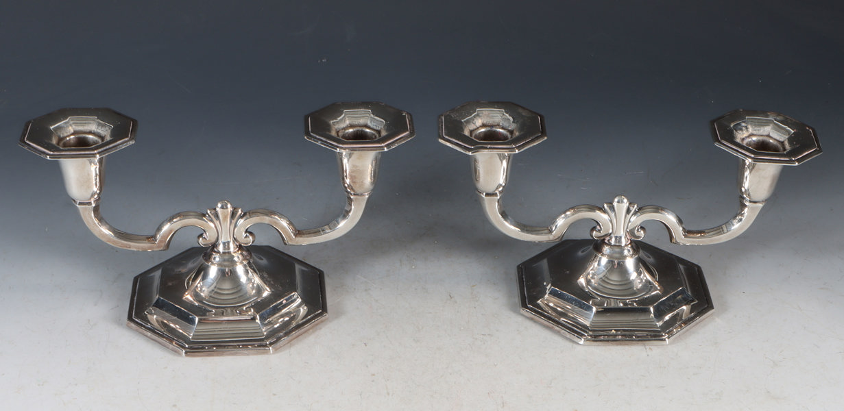 Et par toarmede lysestaker i sølv.