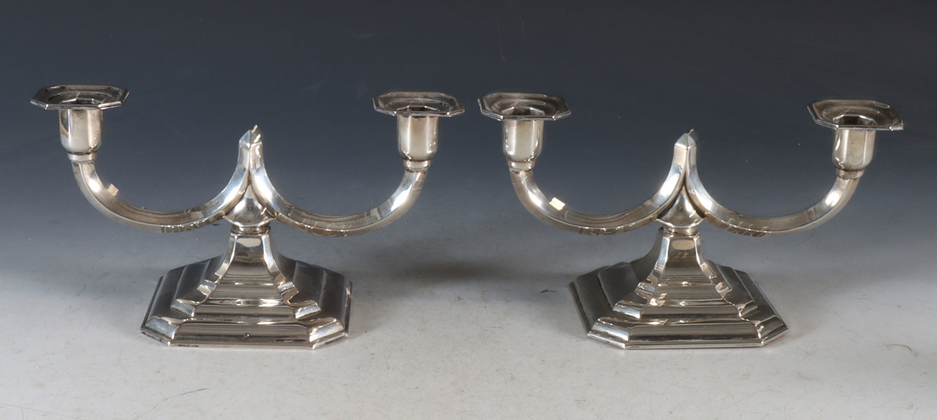 Et par toarmede lysestaker i sølv.