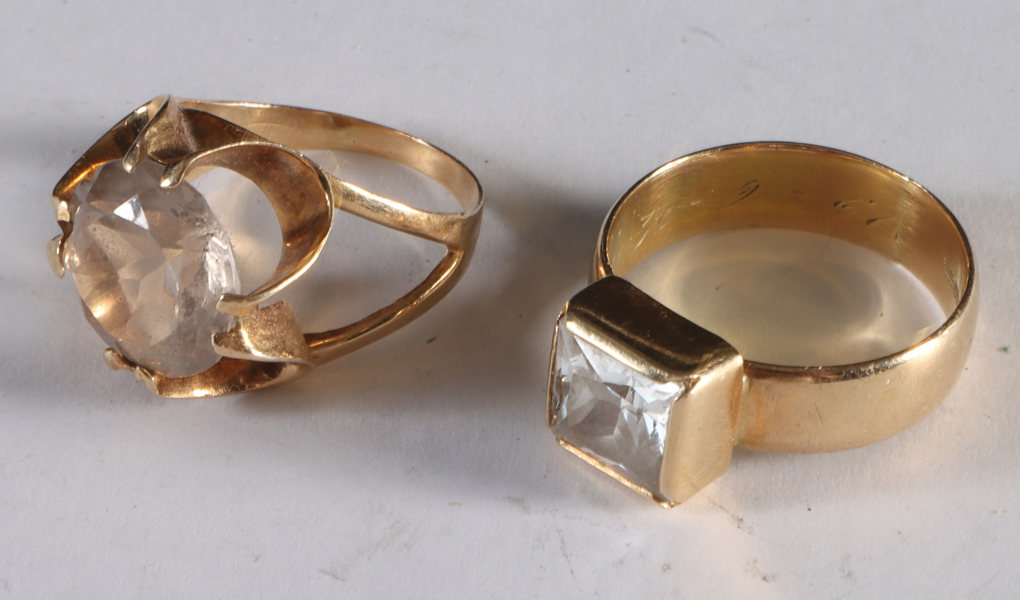 2 ringer i gull med klare stener.
