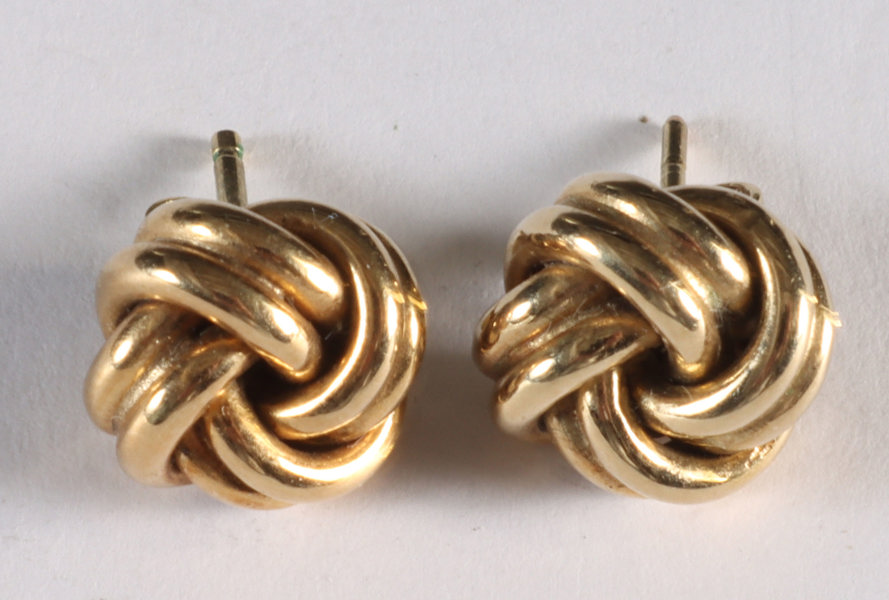 Et par ørepynt i gull, knuter.