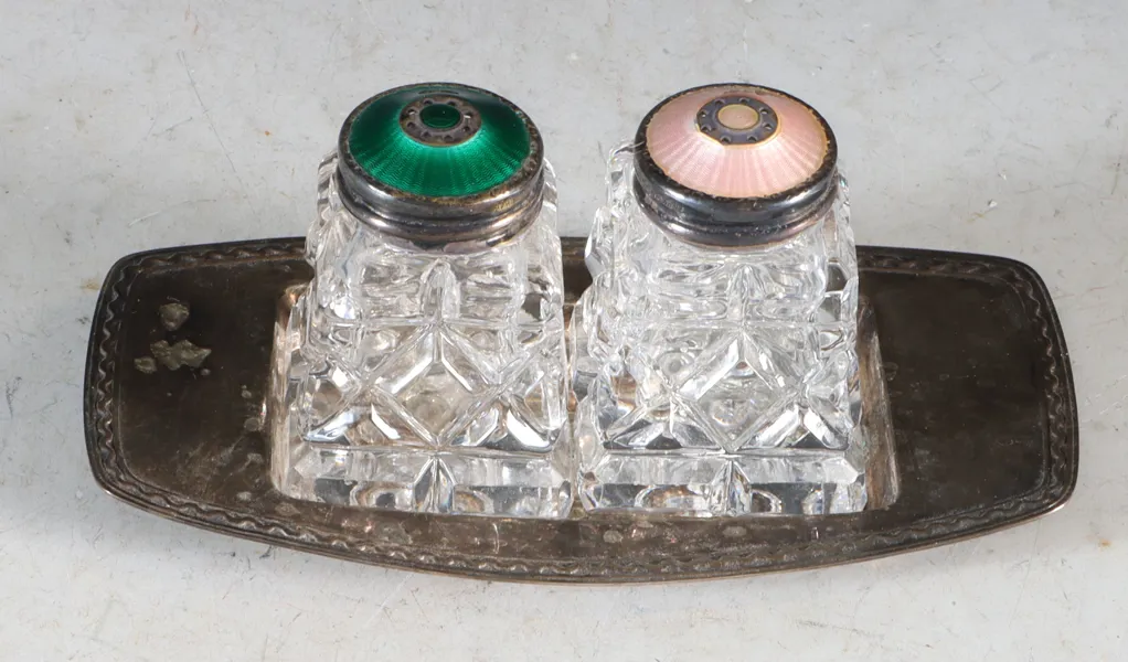 Et par saltdrysser i glass, sølv og emalje.